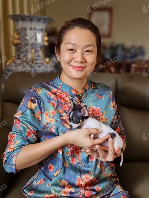 Preview: Portrait of an Asian woman holding her cute pet chihuahua puppy