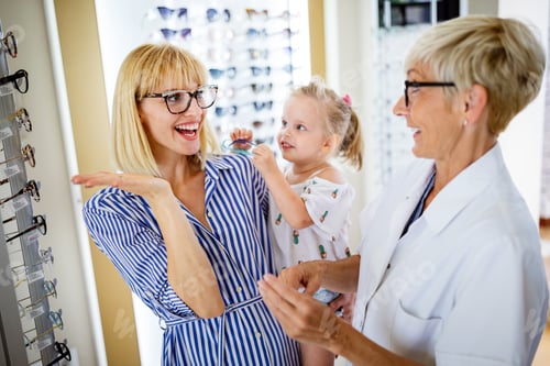 Preview: Happy mother with her cute daughter choosing glasses in optics store