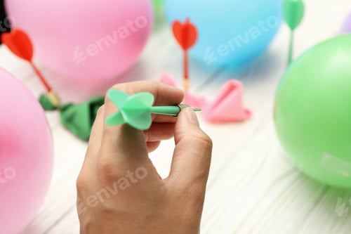 Preview: Throwing wires into balloons, on a light, wooden background.