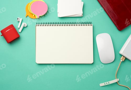 Preview: Open notebook with blank white sheets, computer mouse, wireless headphones and charger