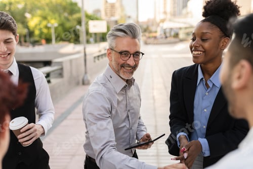Preview: meeting of diverse business people outdoors. - focus on senior man with gray hair shaking hands -
