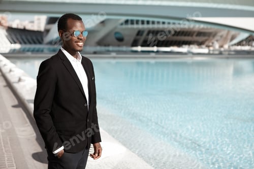 Preview: Cheerful happy young African American office worker wearing black elegant suit and stylish shades st