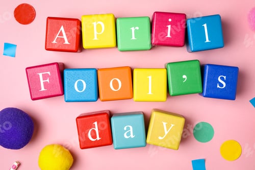 Preview: Colorful cubes with words APRIL FOOL'S DAY on pink background, flat lay