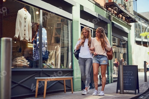 Preview: Full length shot of two attractive young girlfriends exploring a foreign city
