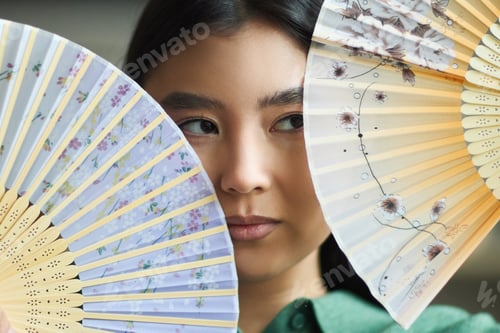 Preview: Portrait of Young Asian Woman Holding Decorative Fans and Looking at Camera