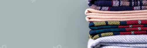 Preview: Stack of woolen checked blankets