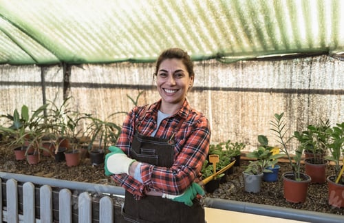Preview: Happy woman working in plants and flowers garden shop
