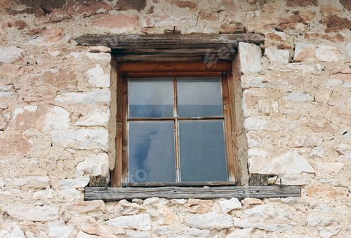 Preview: Old wooden window on the stone wall of a house, background