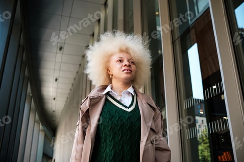 Preview: Albino model female posing in a modern huge corridor outdoors.