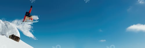 Preview: Snowboarder Jumping in Blue Sky Wide Banner