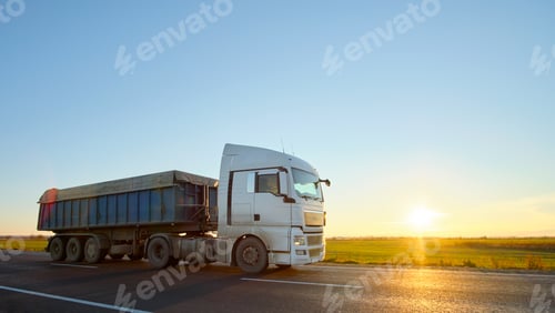 Preview: Semi-truck with tipping cargo trailer transporting sand from quarry driving on highway hauling goods