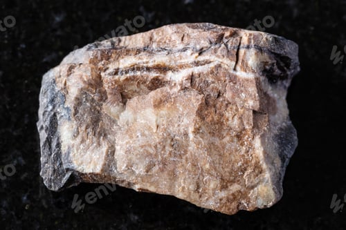 Preview: sample of raw rhodonite mineral on black granite