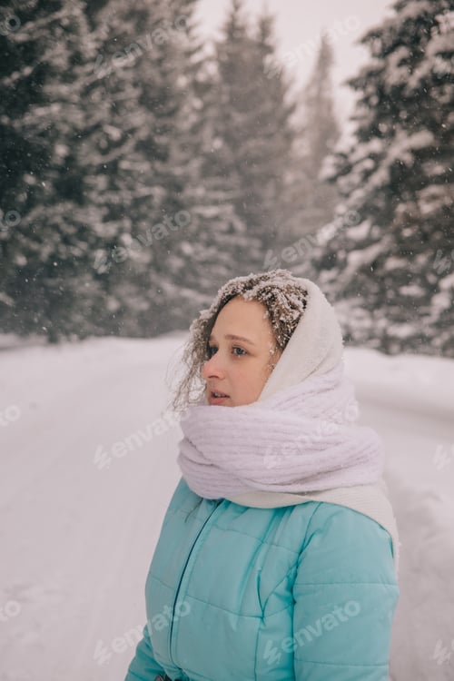 Preview: Caucasian young woman in snowy winter forest