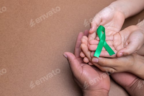 Preview: hands holding green ribbon, liver cancer, chocolate background
