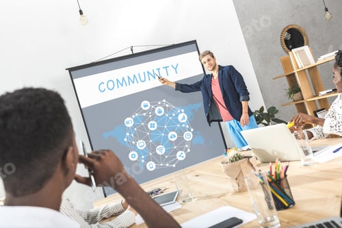 Preview: young businessman making presentation for colleagues at meeting in office