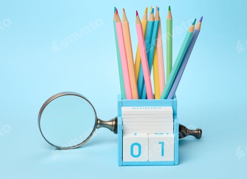 Preview: Multicolored wooden pencils sharpened in a glass on a blue background, school supplies