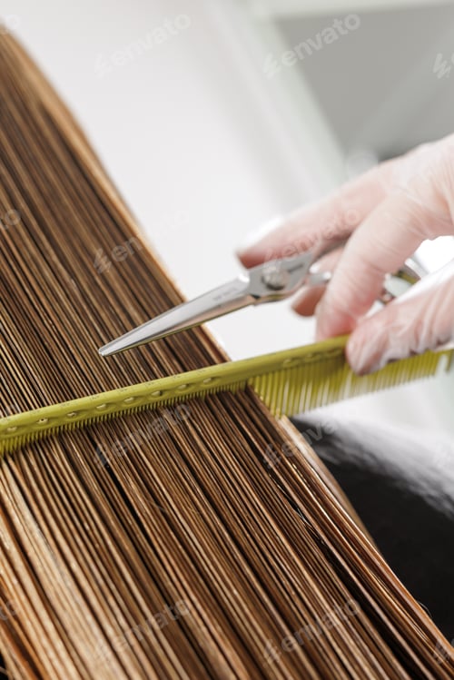 Preview: Vertical close up of precision wet haircut with comb tension and scissors in salon
