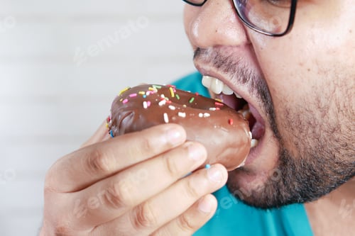 Preview: close up of young man eating donut ,