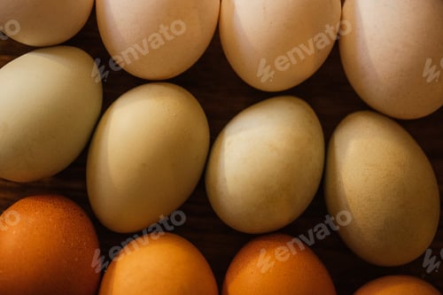 Preview: Assorted eggs in various colors arranged on a wooden surface