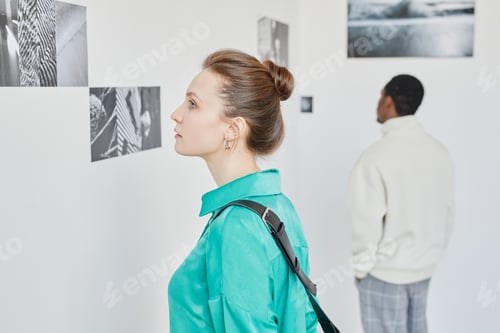 Preview: Young Woman Looking at Pictures in Art Gallery