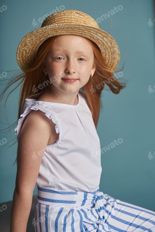 Preview: Young red-haired girl in a straw hat with long beautiful hair and big blue eyes. Hair color of fire