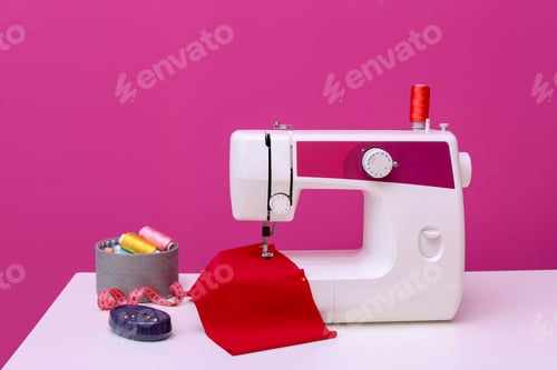 Preview: Modern sewing machine on table against color background