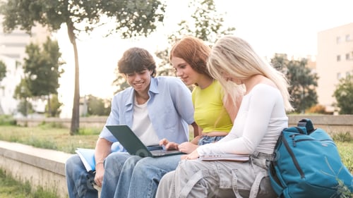 Preview: Happy young friends using netbook on university campus