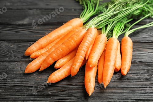 Preview: Ripe carrots on wooden background. Healthy diet