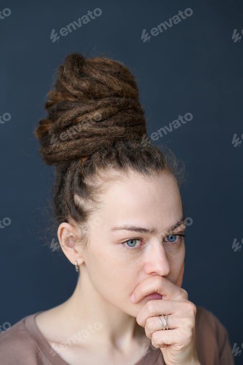Preview: Close Up Woman with Dreadlocks in Bun Looking Away Concerned Face Expression