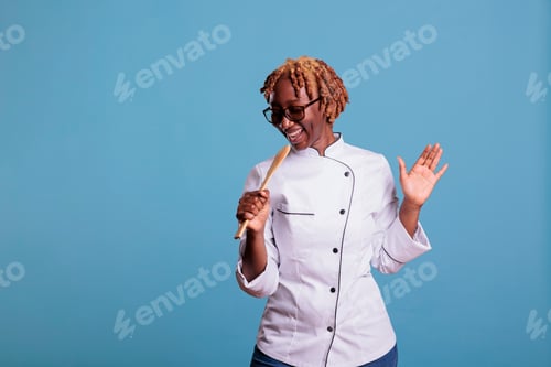 Preview: African american cook portrait singing with kitchen utensil