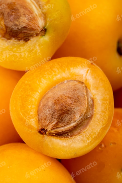 Preview: close-up view of half cut apricot with whole apricots as background