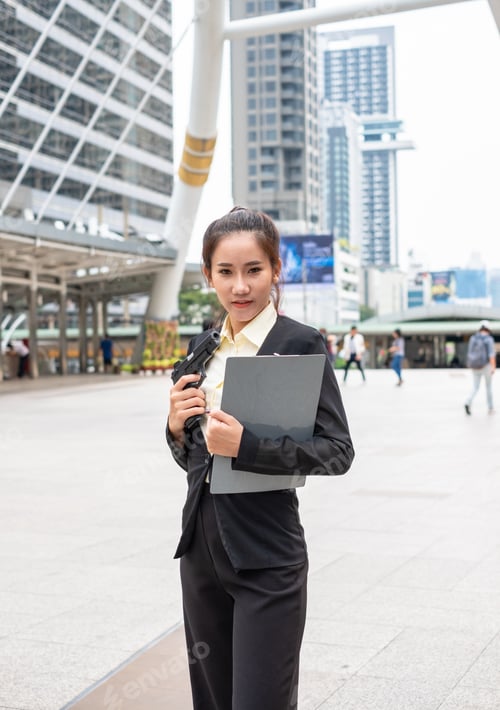 Preview: Asian businesswoman holding carbine and clipboard standing on the city