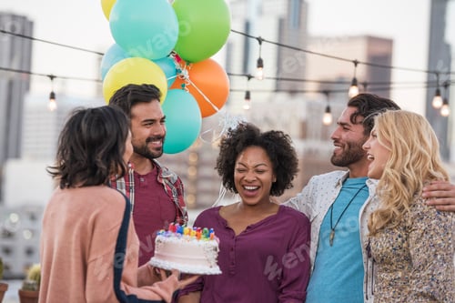 Preview: Friends celebrating birthday party on rooftop with birthday cake