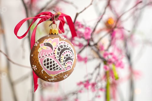 Preview: Handmade Christmas ball hanging on a branch, on a red ribbon.