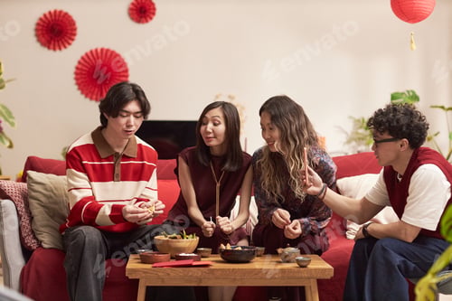 Preview: Group of Young Adult Asian Friends Sharing Traditional Food during Holiday Gathering