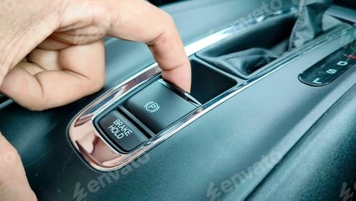 Preview: Finger pressing the electronic parking brake button on luxury car. Electric electronic Parking Brake