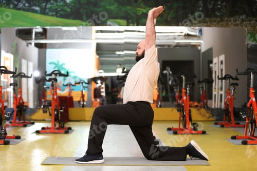Preview: Overweight man doing exercise in gym
