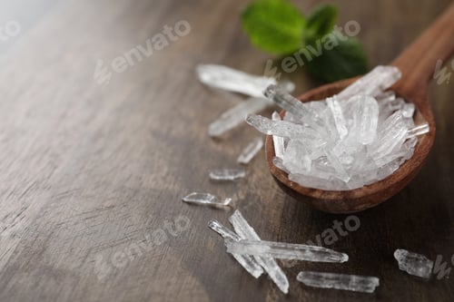 Preview: Menthol crystals on wooden background, closeup. Space for text