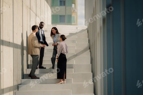 Preview: Business people talking on stairs of modern office building