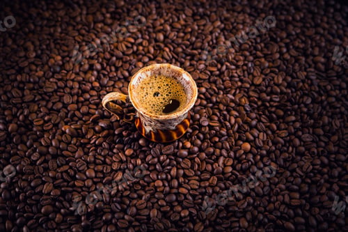 Preview: Cup of coffee on roasted coffee beans.