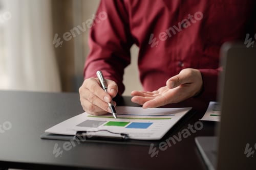 Preview: Business man pointing to a pie chart document showing company financial information, He sits in her