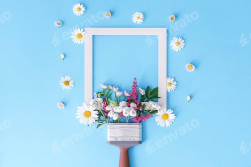 Preview: Creative layout of both brush and flowers on a blue background. Floral composition.