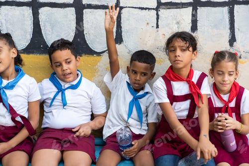 Preview: LA HABANA, CUBA - NOVEMBER, 6 , 2018: Happy girls in pioneer uniforms passing rock