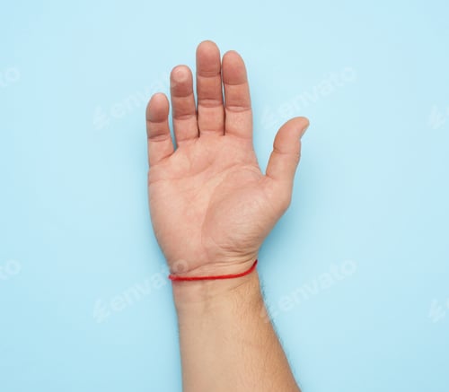 Preview: Red woolen thread on the wrist of a male hand