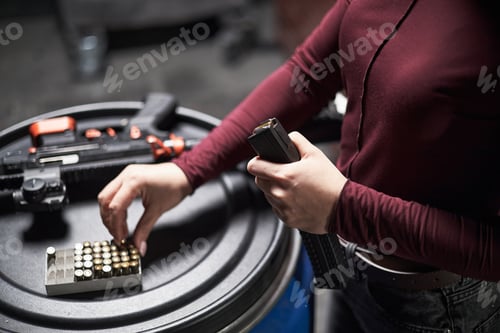 Preview: Anonymous Woman Loading Magazine with Ammunition at Shooting Club
