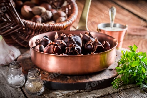 Preview: Fresh chestnuts with garlic sauce on old wooden table