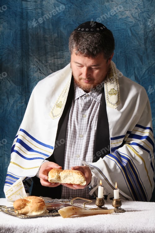 Preview: A man breaks Saturday's festive bread Homemade challah on Shabbat