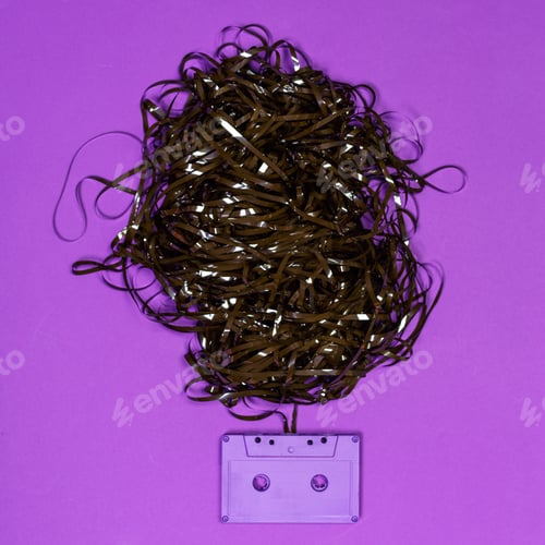 Preview: Stuck cassette tape with tangled magnetic tape on purple background