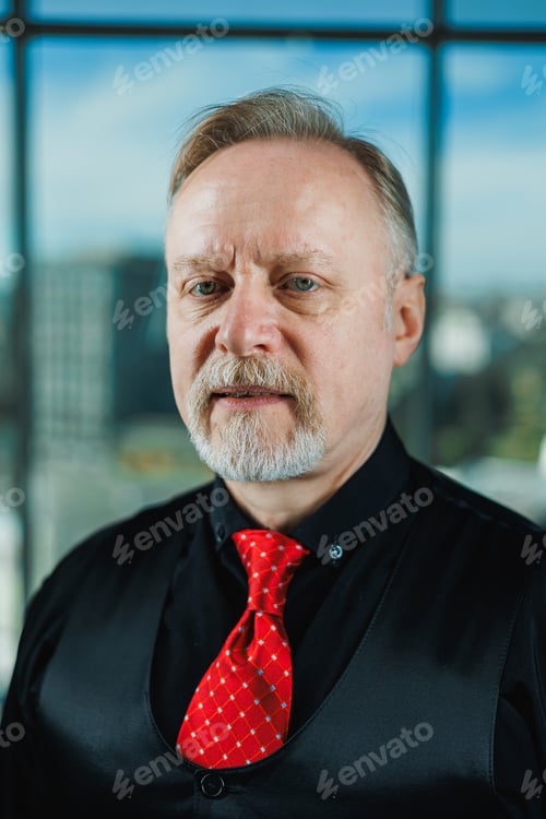 Preview: An old bearded man in a black shirt with a piercing look. Close-up portrait of a bearded