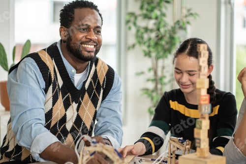 Preview: Smiling African American teacher watching student arranging wood toy in the classroom